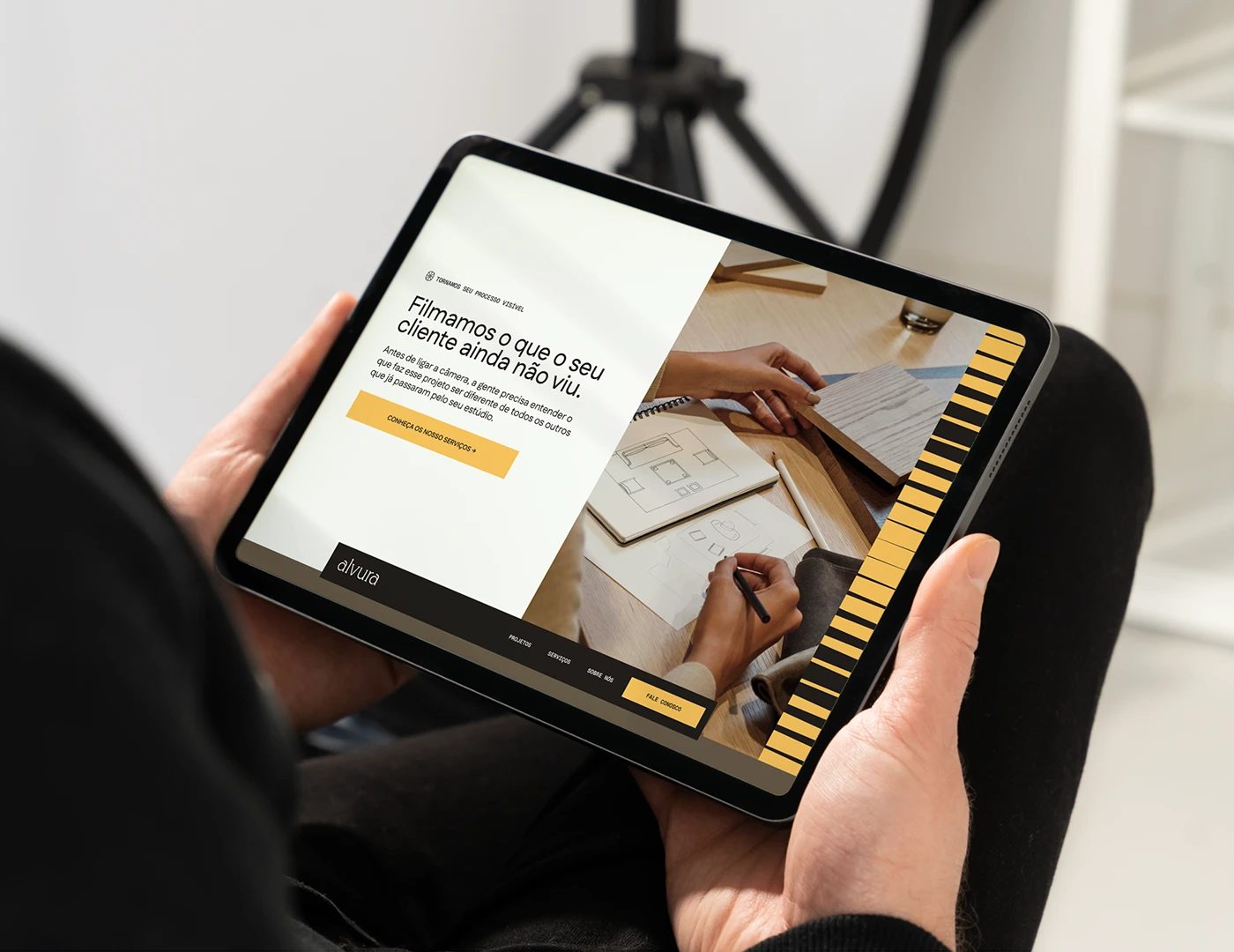 Alvura Filmes branding tablet web portfolio interface held in hands