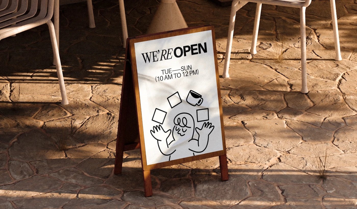 Four Squares Cafe sidewalk A-frame sign: we are open, come and stay a while