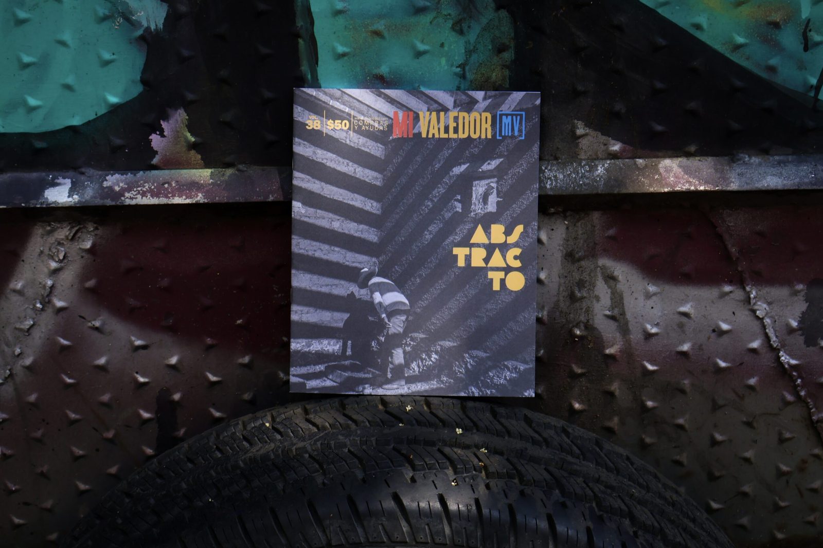 Revista Mi Valedor Vol. 38 'Abstracto' cover with gold geometric typography shot on a city street