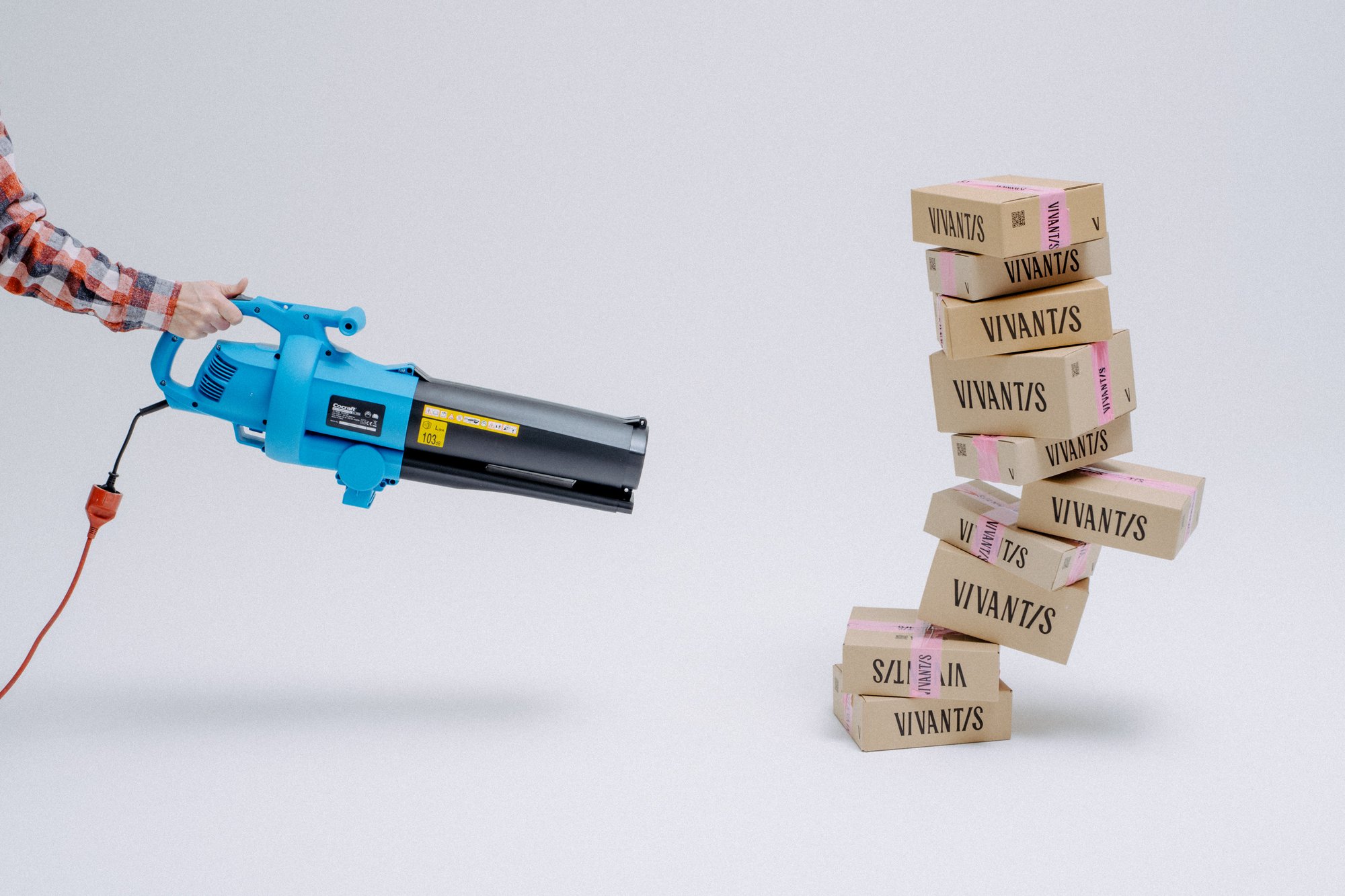 Leaf blower aimed at a tower of Vivantis branded boxes