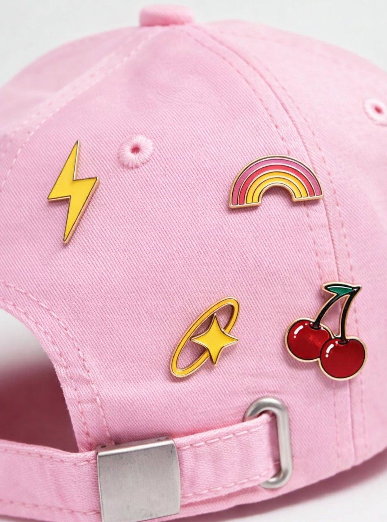 Enamel pins from the Vivantis icon set on a pink cap