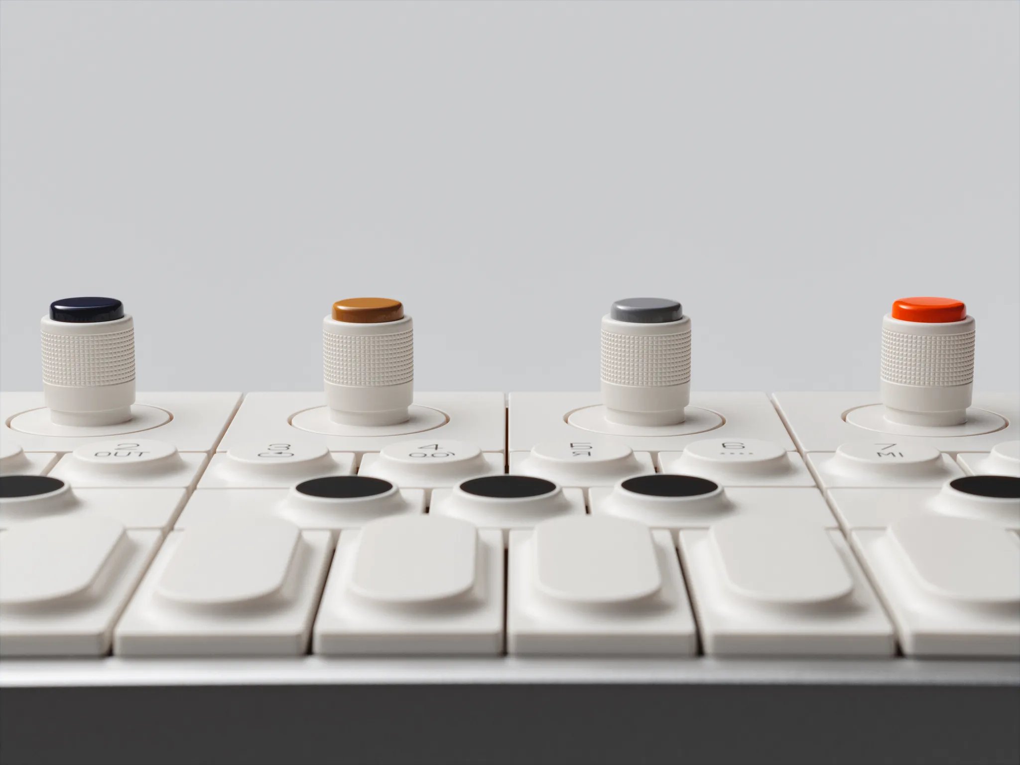 Close-up of the OP-1 field encoders with dark blue, ochre, grey and orange caps