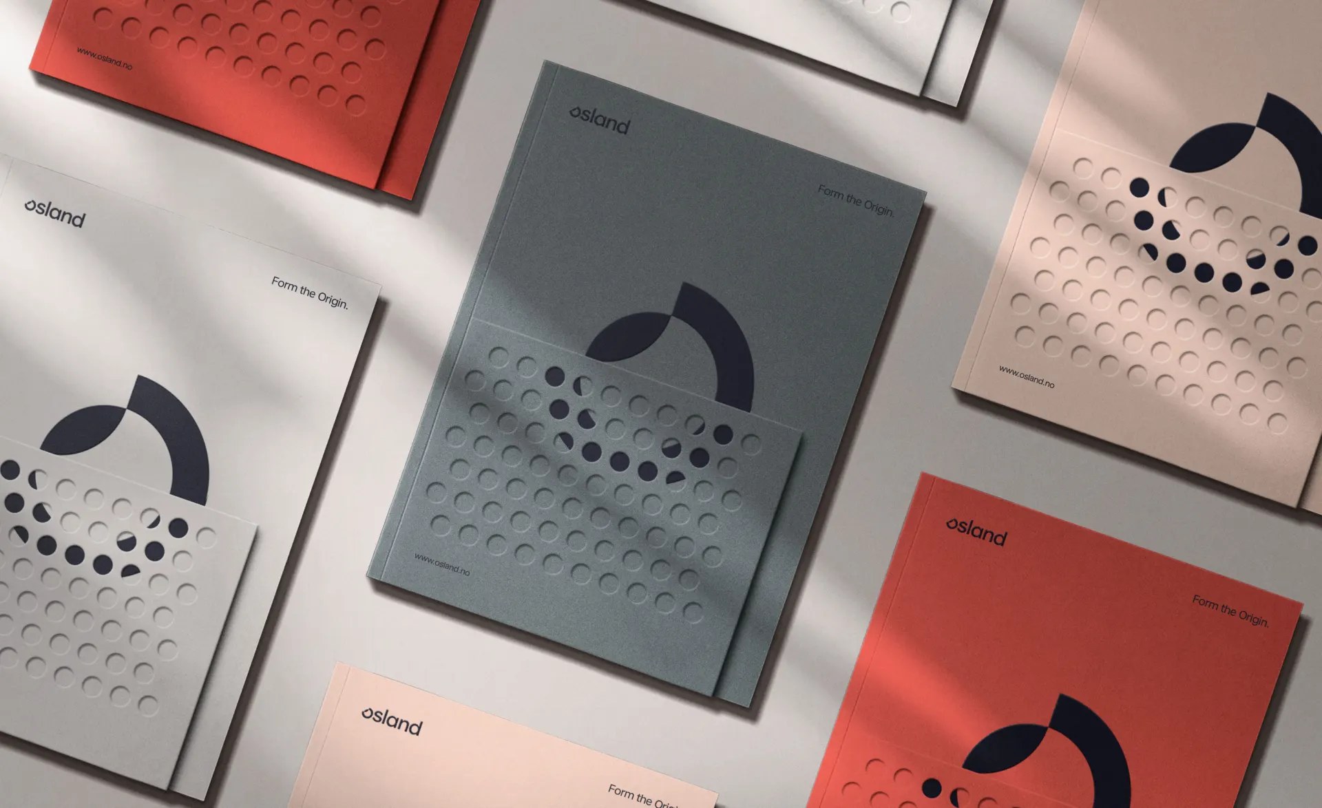 Osland identity stationery flat-lay: folders with the circular roe-dot motif in coral, grey and sand