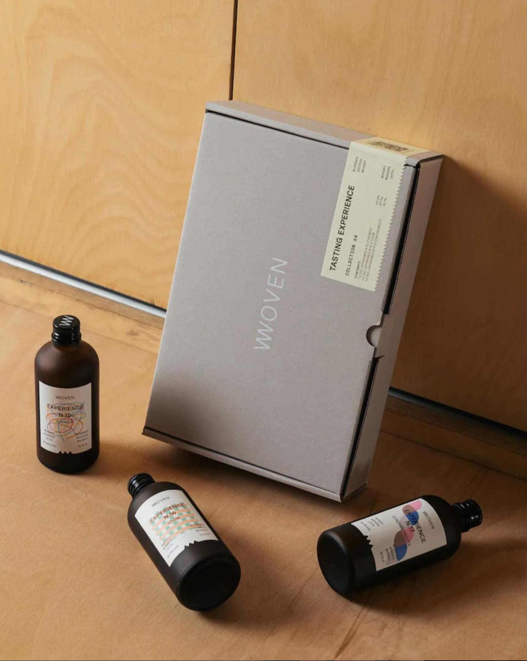 Grey Woven tasting experience box with three small Experience bottles beside it.