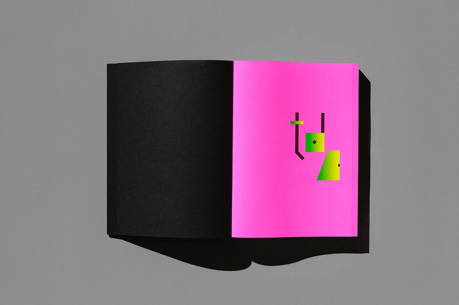 Opening endpaper spread pairing matte black paper with the acid-green and yellow tdc counterform emblem on fluorescent pink stock — editorial design by Tereza Bettinardi