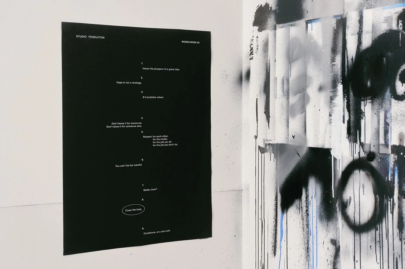 Black Studio Pendleton manifesto poster with typographic principles pinned beside spray-painted artwork by SAVVY STUDIO