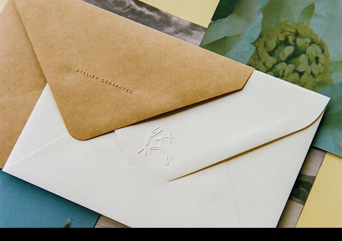 Blind debossed Atelier Cervantes typography and embossed emblem on tactile stationery envelopes by SAVVY STUDIO