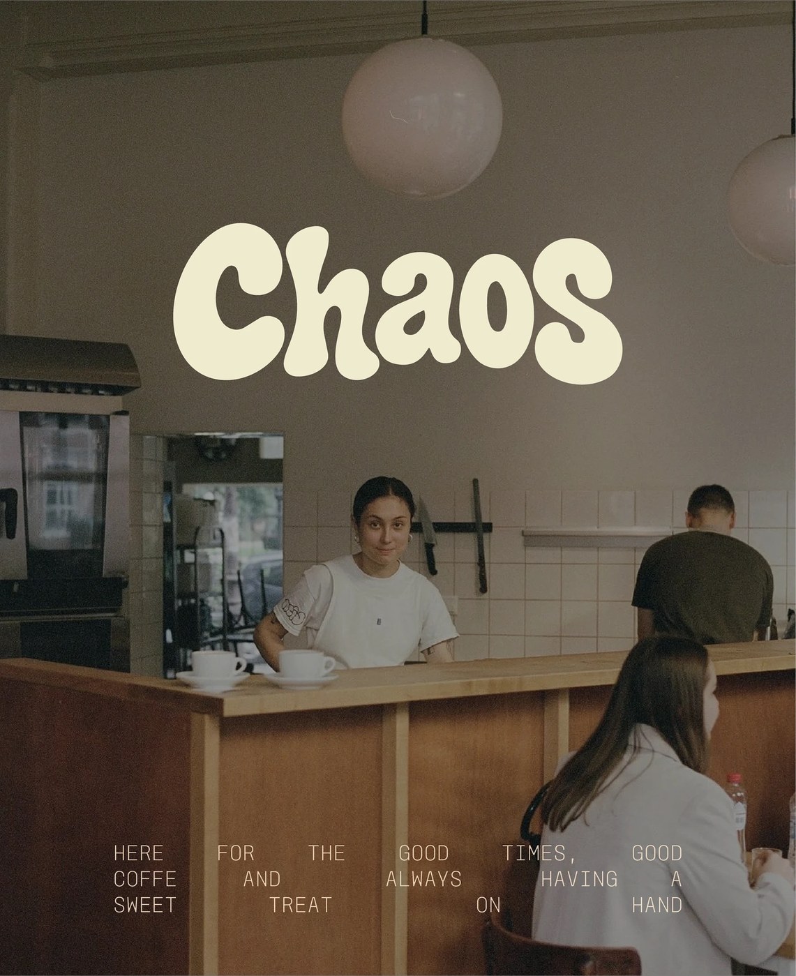 Barista behind the cafe bar wearing an embroidered Chaos baseball cap and matching branded uniform