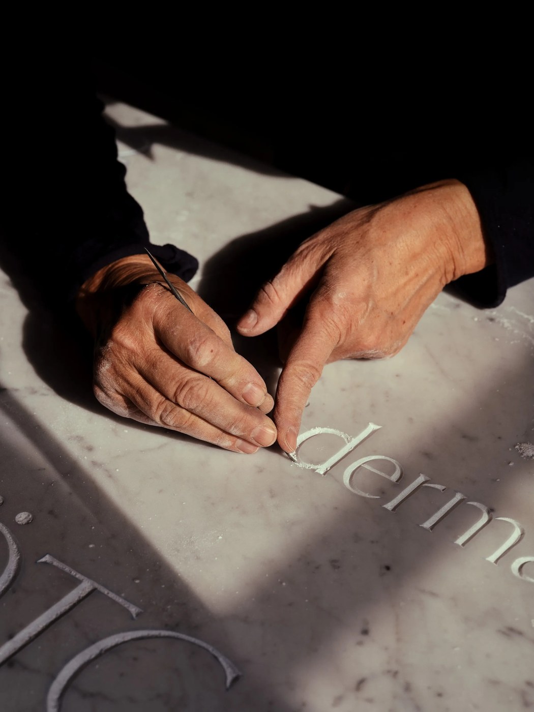 Artisan hands carving lowercase d into Carrara marble — typography by Letters from Sweden