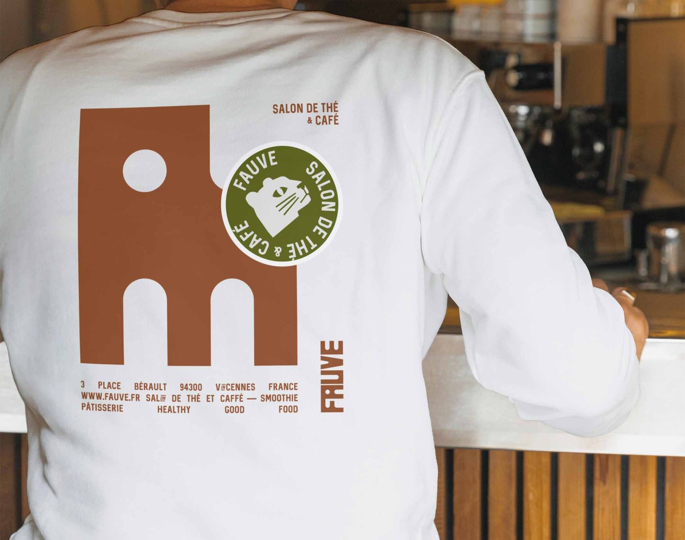 FAUVE brand identity staff uniform back print with arch graphic and green badge