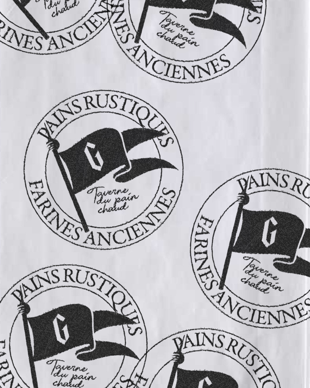 Repeating black ink circular heraldic stamp pattern with swallowtail G battle flag on wrapping paper — branding by Charline GROEN