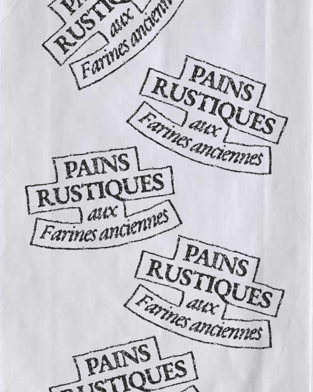Grainy black rubber-stamped ribbon banners reading Pains Rustiques aux Farines Anciennes on white paper — branding by Charline GROEN