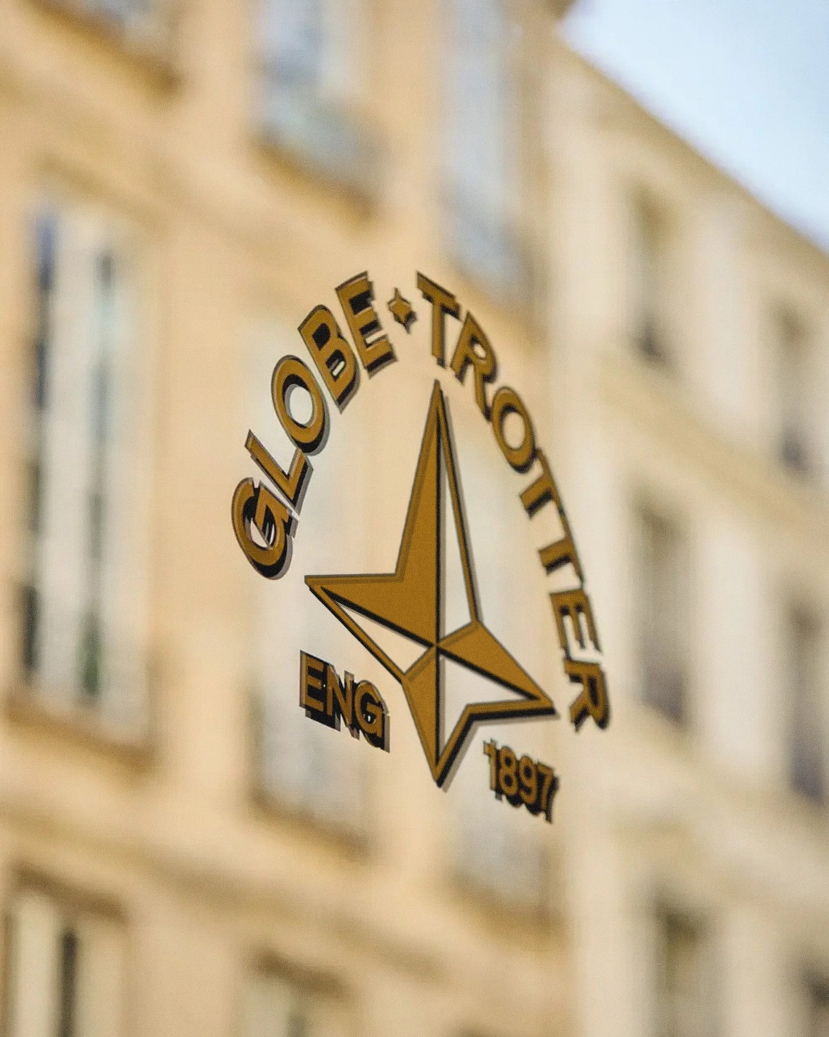 Gold-leaf arched Globe-Trotter ENG 1897 window mark and faceted North Star symbol on glass — brand identity by Ragged Edge