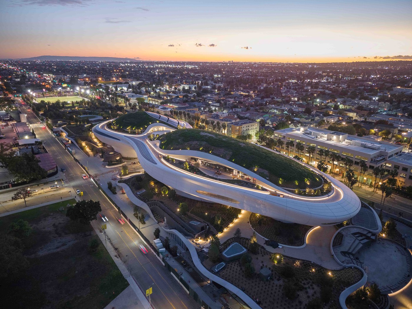 Lucas Museum exterior illuminated at dusk showcasing the aerodynamic cloud silhouette