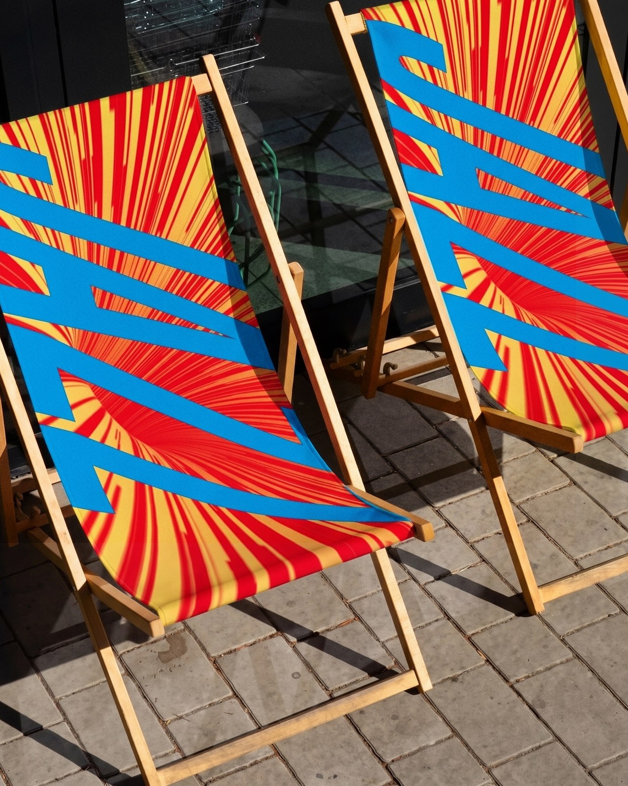 Festival deck chairs with bold pattern and typography in Montreal Jazz Festival visual identity
