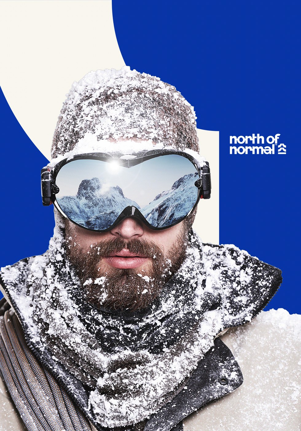 Winter mountaineer portrait with snowy goggles reflecting alpine peaks in North of Normal branding design