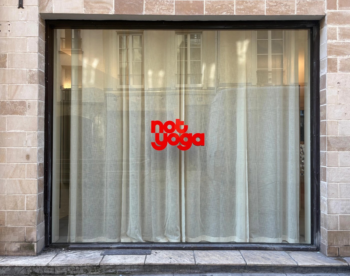 visual identity brand overview with dimensional red logo and typography on Paris storefront window
