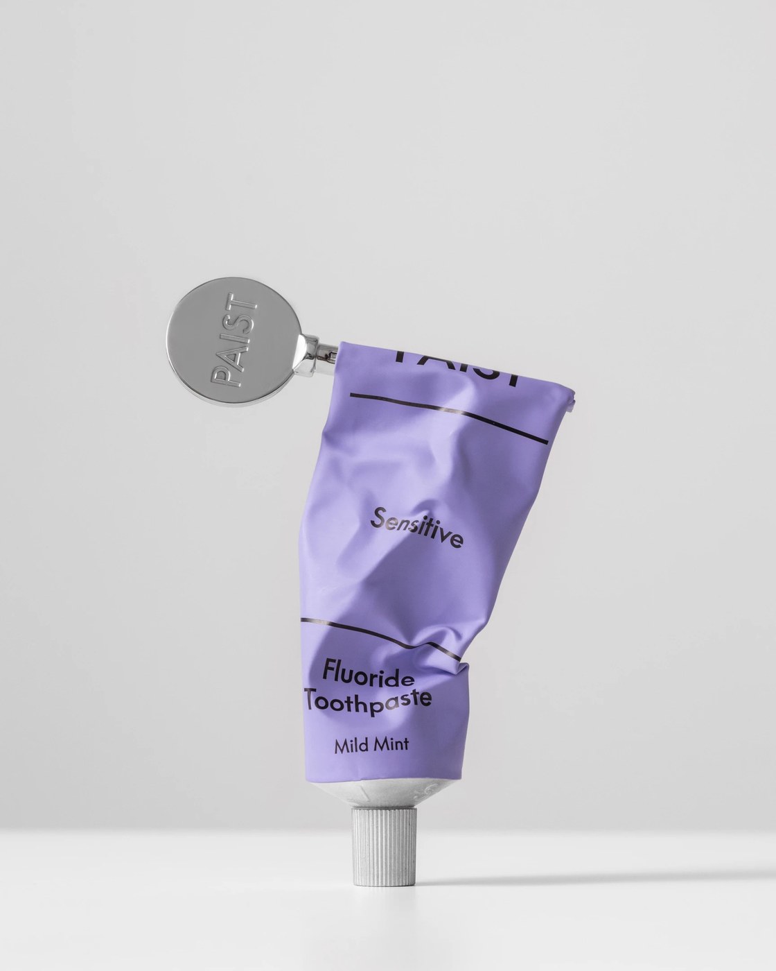 Paist lilac sensitive toothpaste tube fitted with engraved circular chrome key winder tool