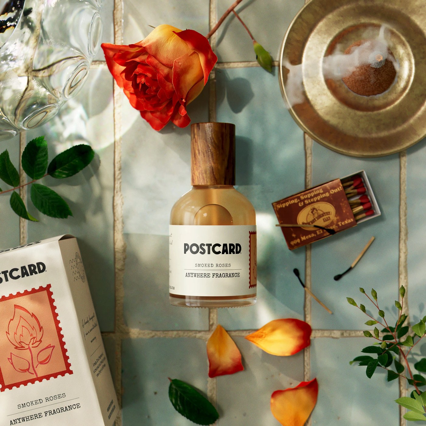 Postcard Smoked Roses Anywhere Fragrance glass bottle with wooden cap and red stamp carton — packaging design by Robot Food