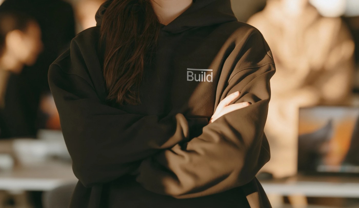Heavyweight dark brown hoodie featuring the embroidered overline 'Build' mark on the chest