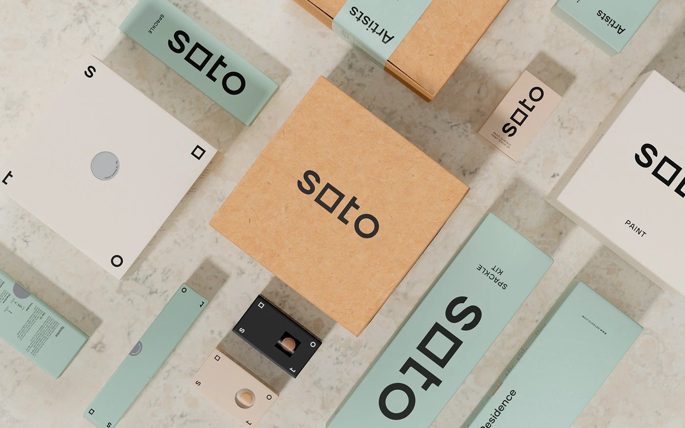 Soto branding full system flatlay — kraft boxes, sage green spackle kits, cream paint cans, and tools on white marble