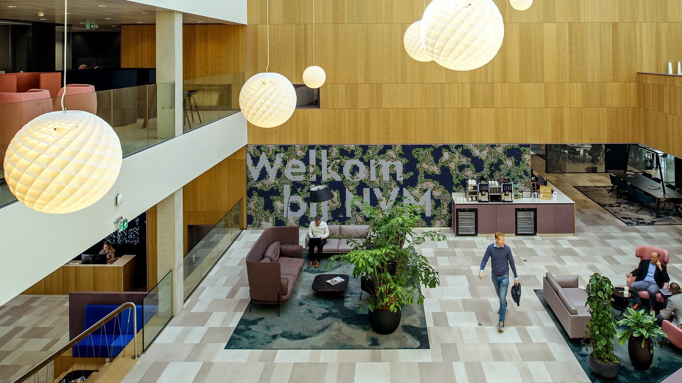 Central sunlit atrium featuring hospitality seating and spatial design mosaic wall