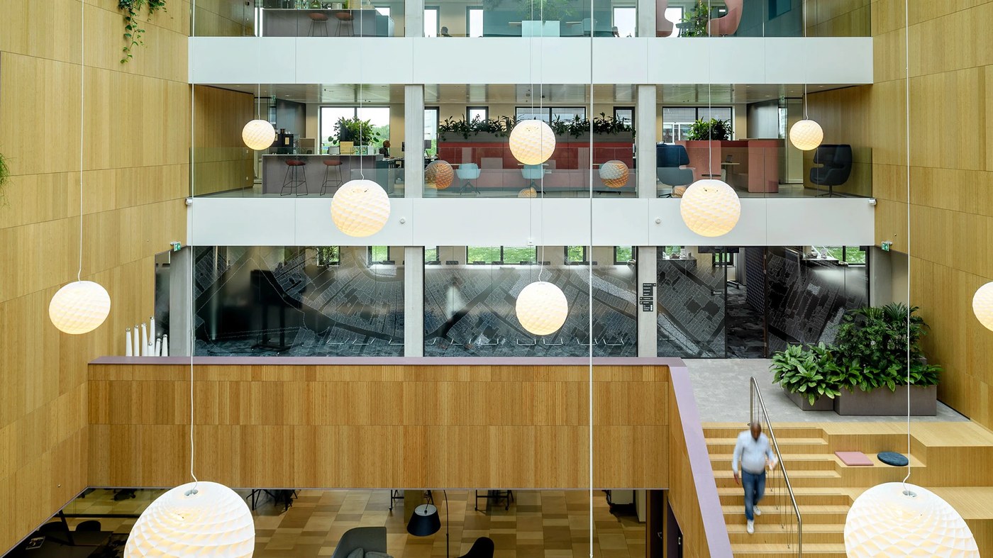 Multi-level atrium interior with timber paneling and spatial design graphics