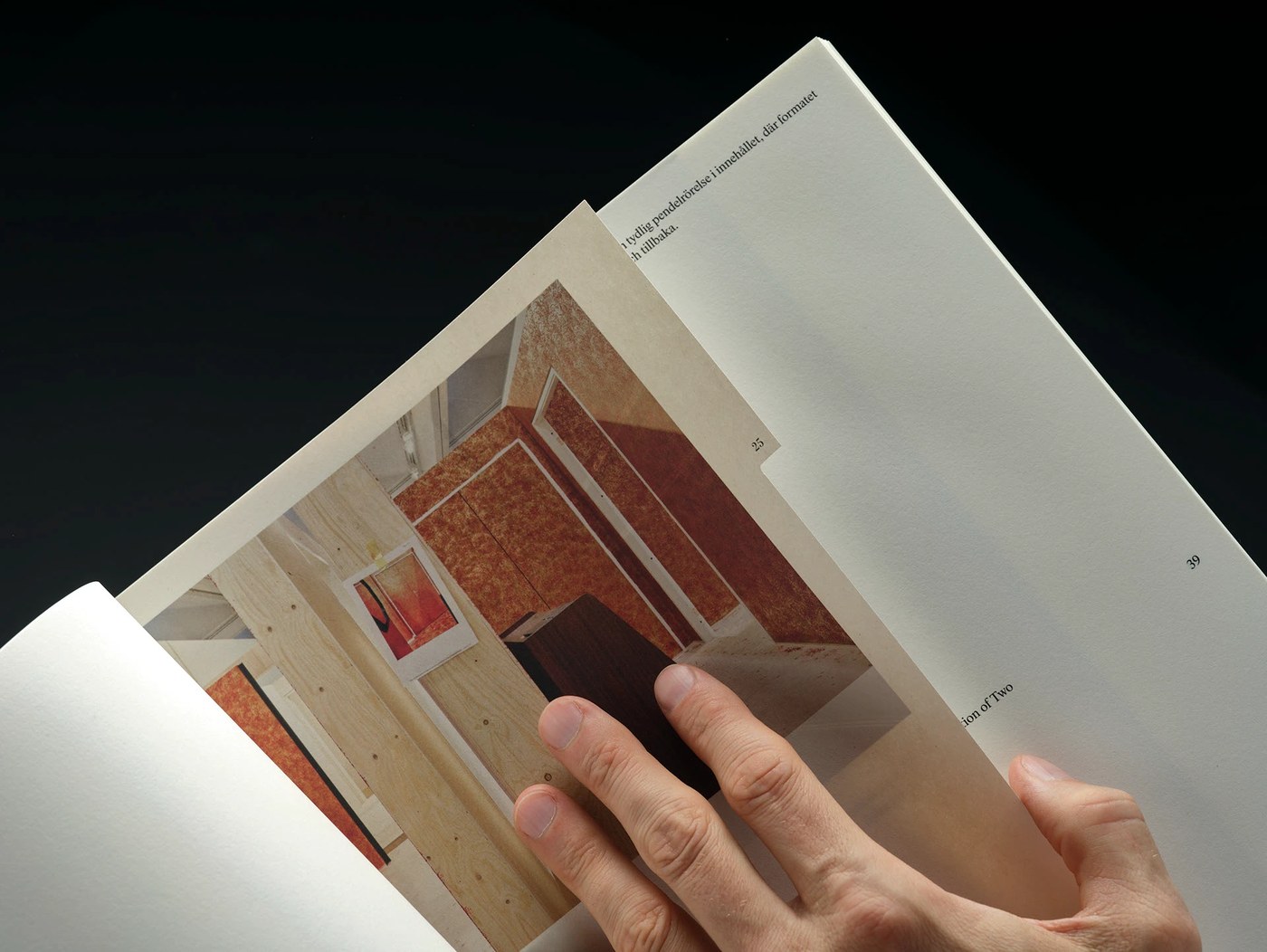 Hand turning an authentic book leaf bound into Svensk Bokkonst catalogue demonstrating tactile editorial design
