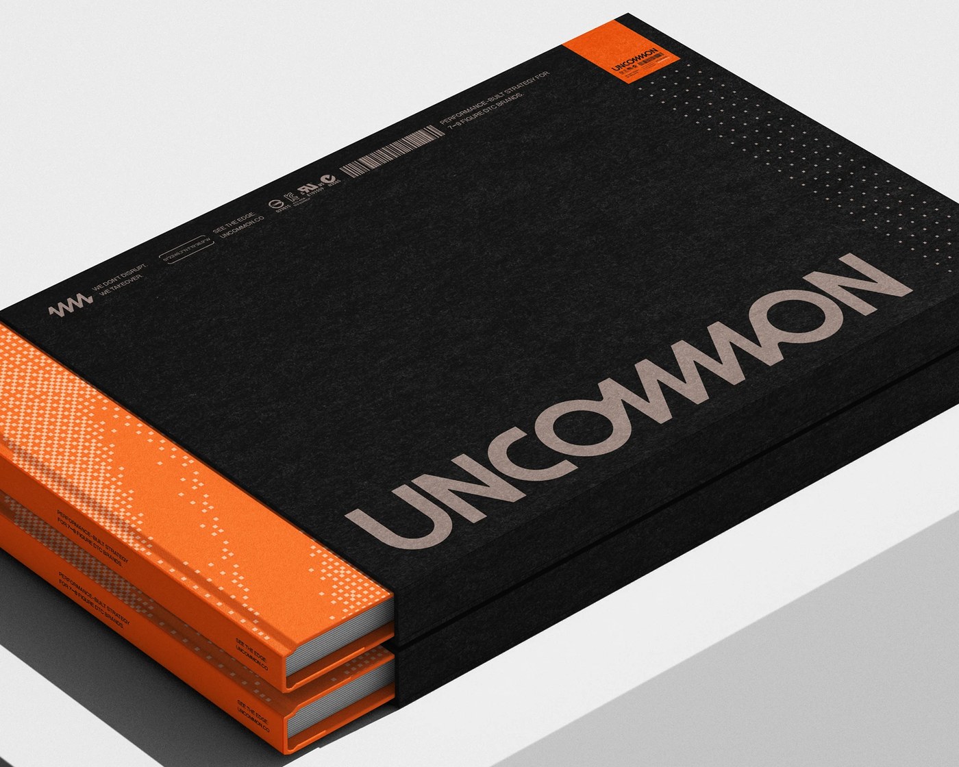 Uncommon brand identity textured black slipcase editorial book suite with safety orange telemetry