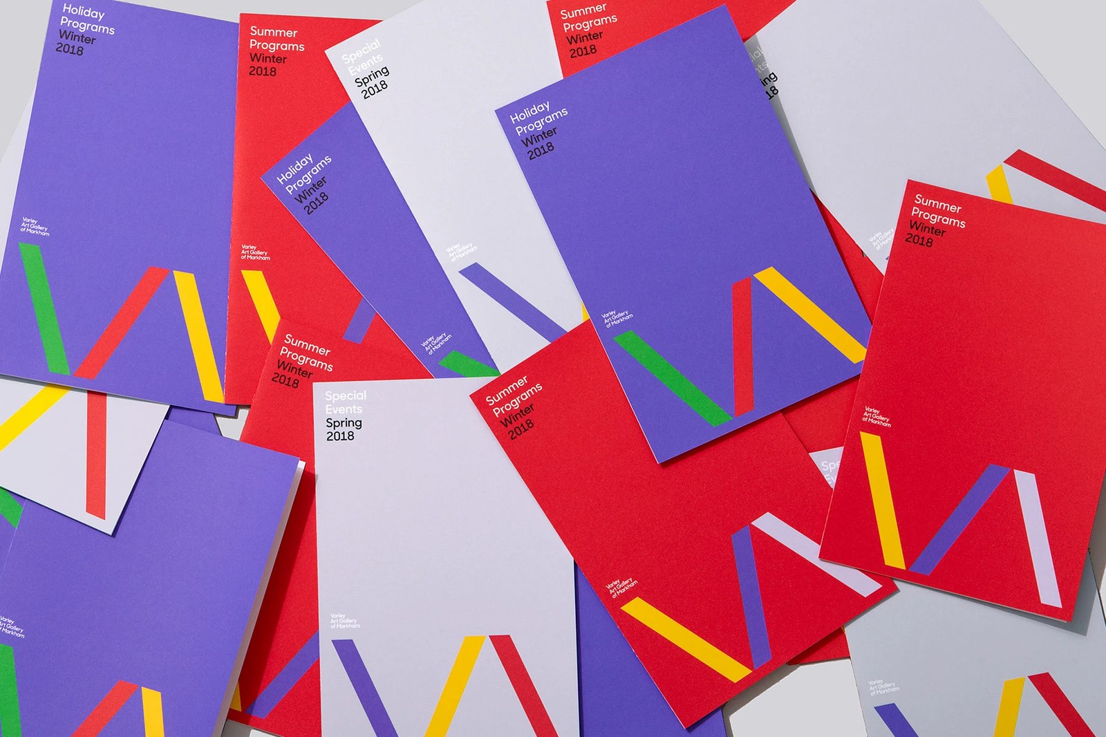 Varley Art Gallery identity spread of overlapping program booklets with color palette variations across the VA monogram and typography by Underline Studio