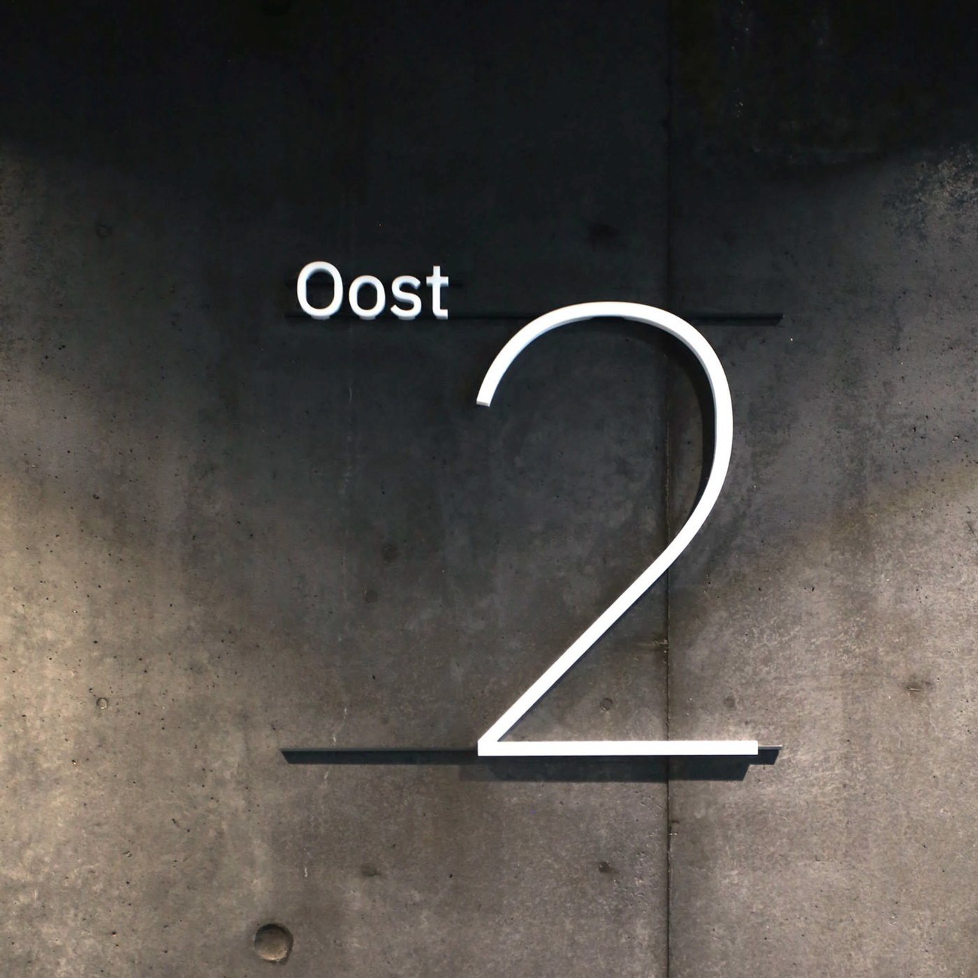 Floor level two numeral on raw concrete wall in spatial design system by Silo