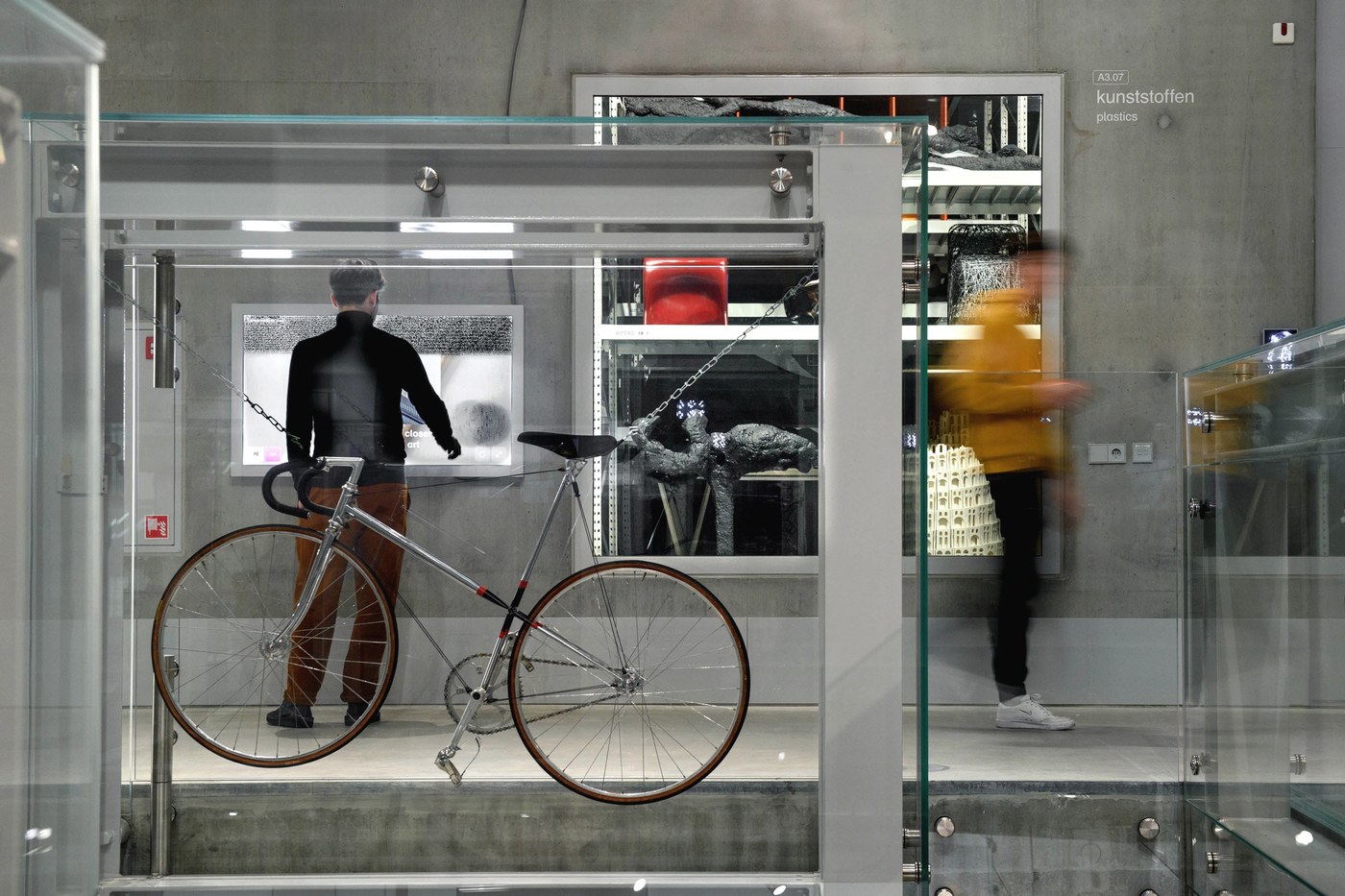 Glass vitrine holding a suspended bicycle and artwork in spatial design by Silo