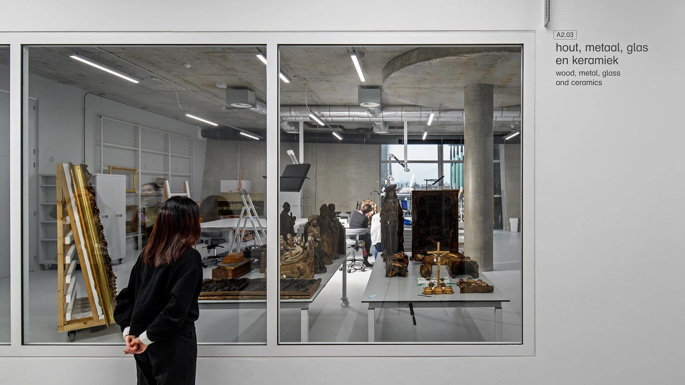 Art conservation studio viewed through glass with room signage in spatial design by Silo