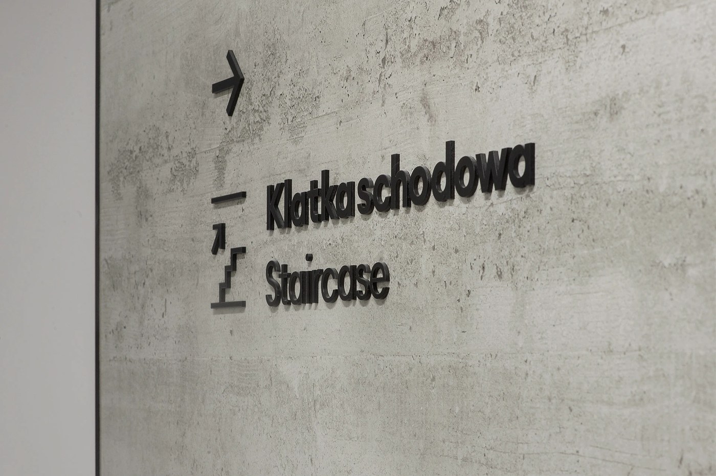 Spatial design dimensional black staircase lettering on textured concrete for FORMAT by Blank Studio