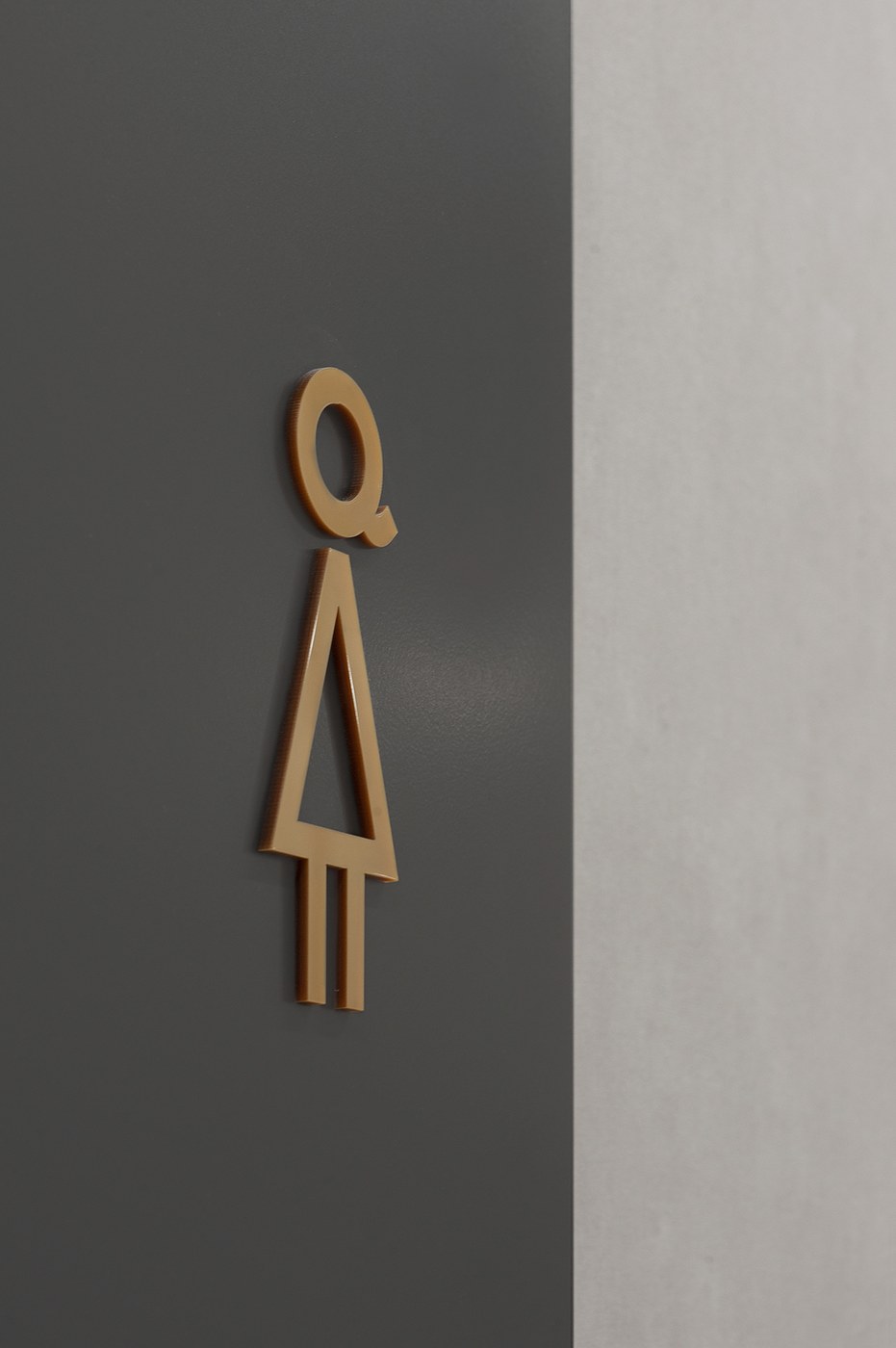 Spatial design dimensional female restroom glyph in ochre acrylic for FORMAT by Blank Studio