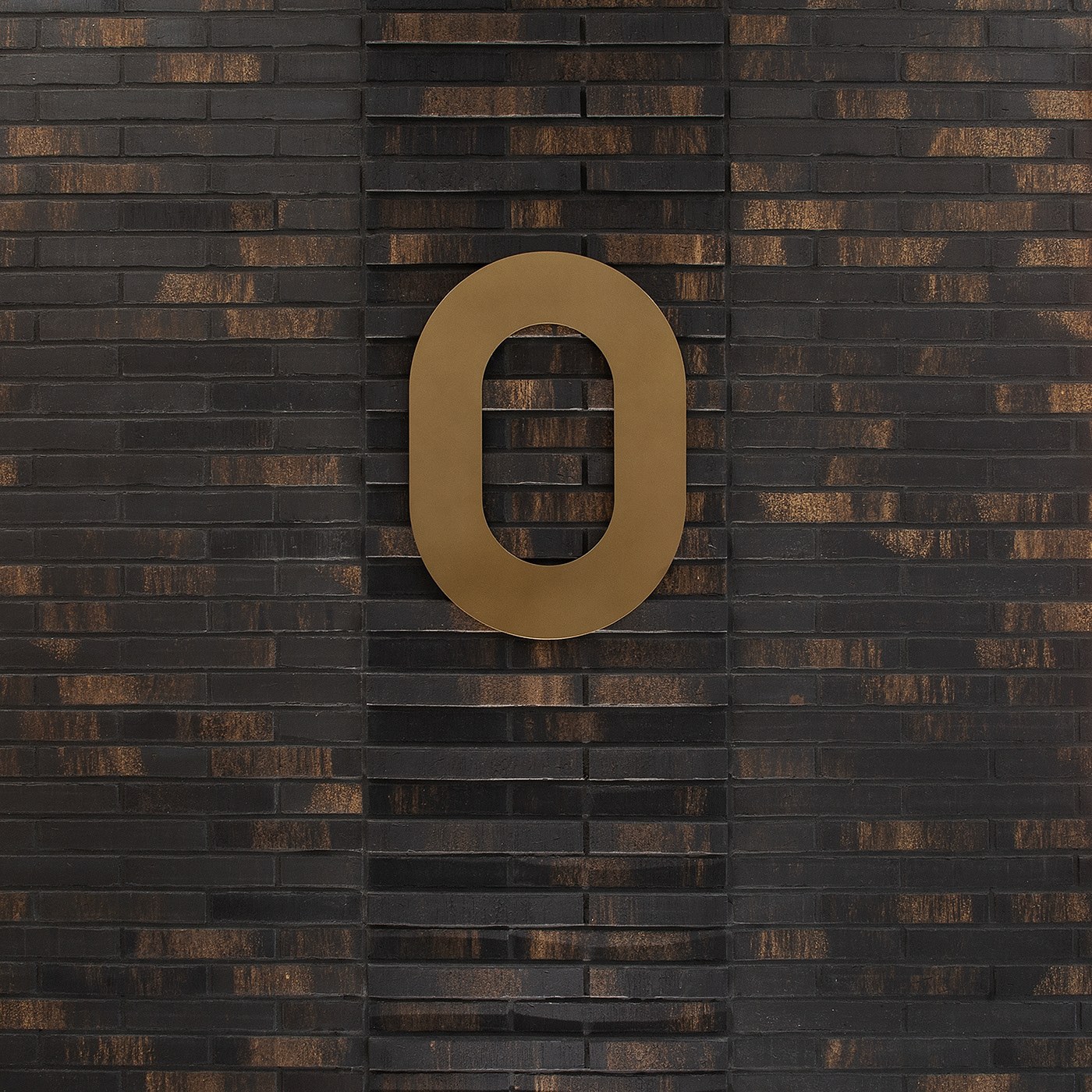 Spatial design bronze level zero numeral mounted on clinker brick facade for FORMAT by Blank Studio