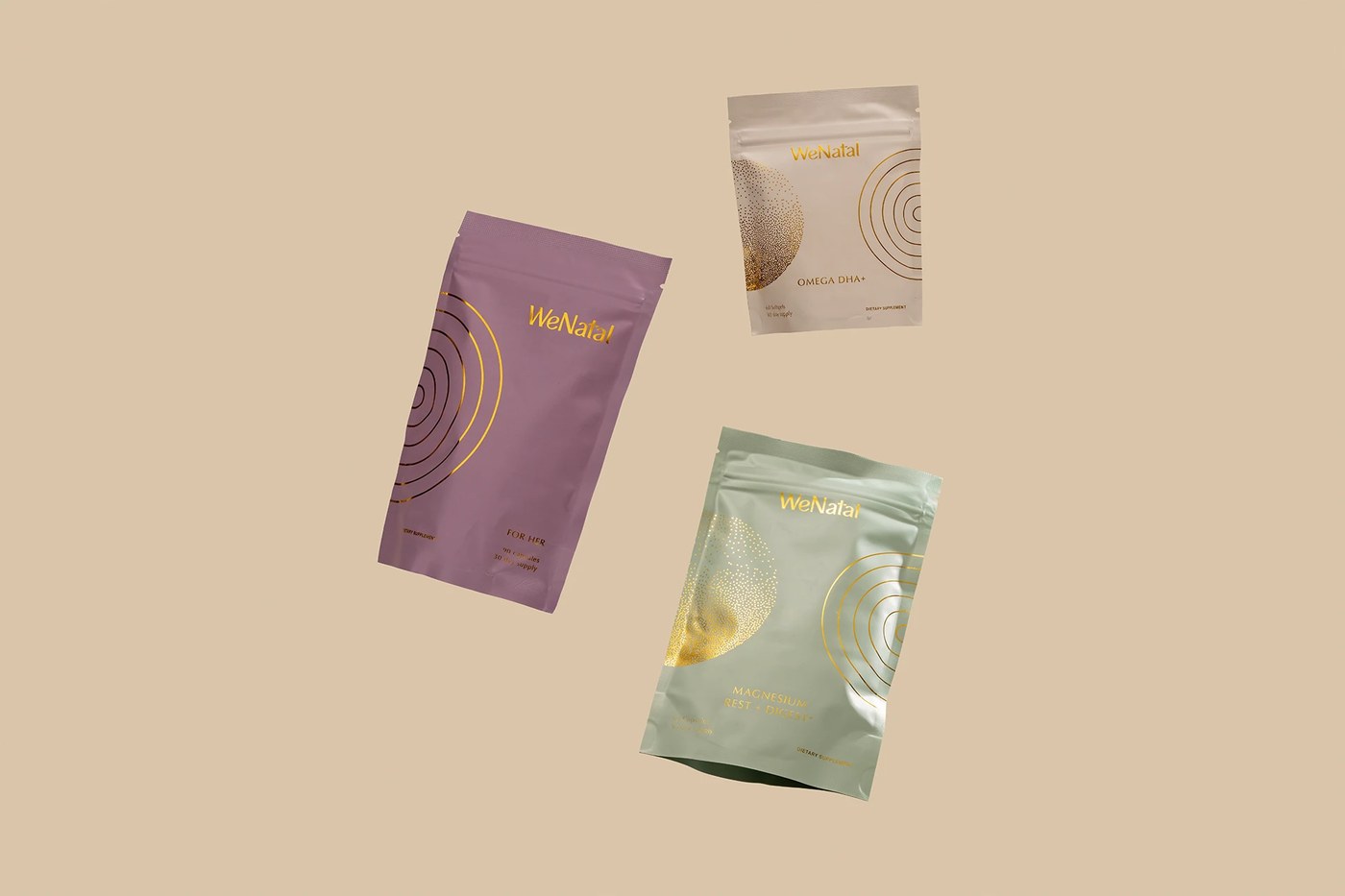 Lilac, sage green, and white resealable supplement pouches with gold foil WeNatal typography and line graphics in packaging design