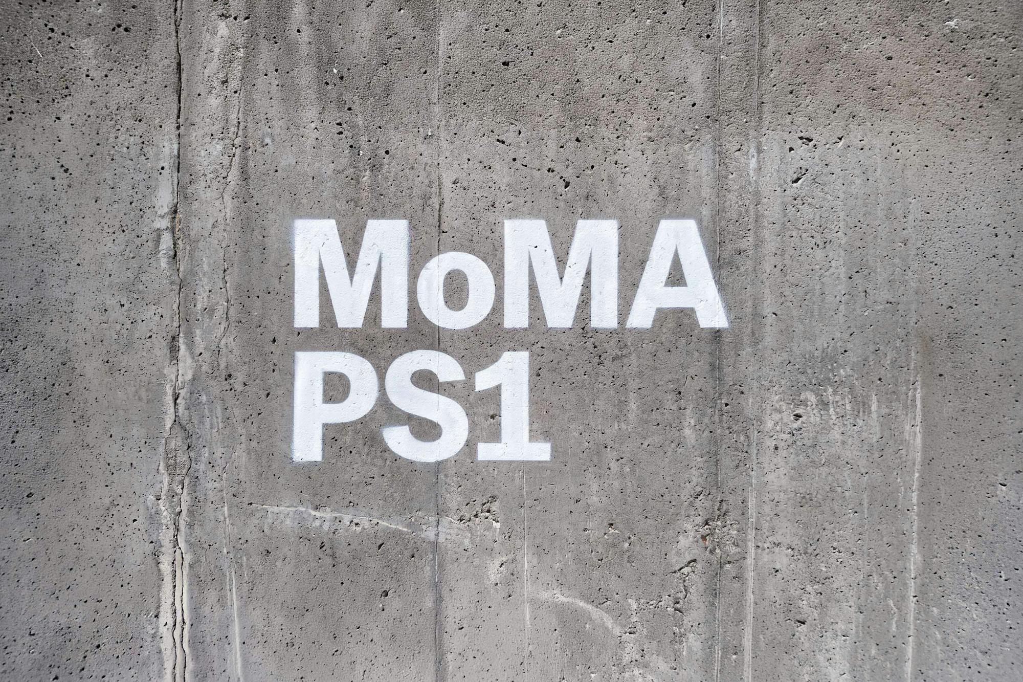 MoMA PS1 wordmark stenciled in white directly onto raw concrete