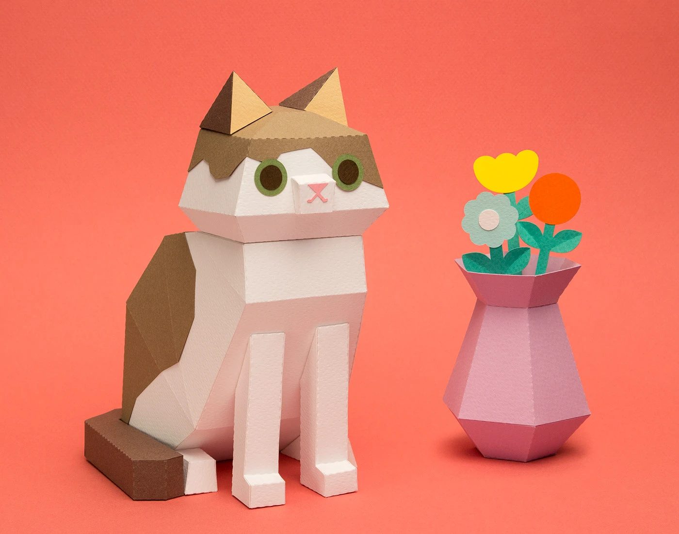 Kitten Paper Kits calico cat sculpture and paper vase design on coral backdrop