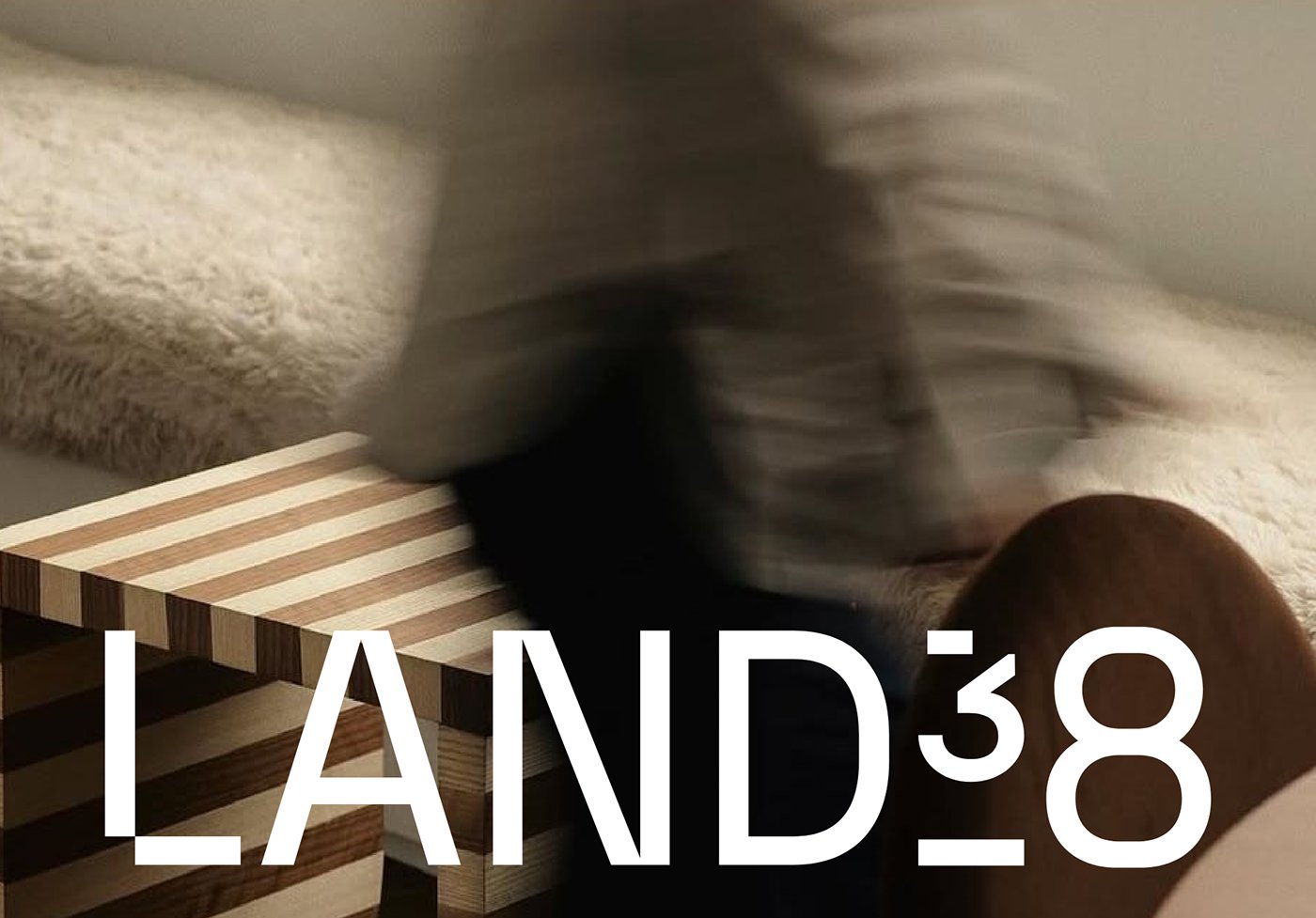 LAND38 brand visual identity interior photograph with timber stool and wordmark