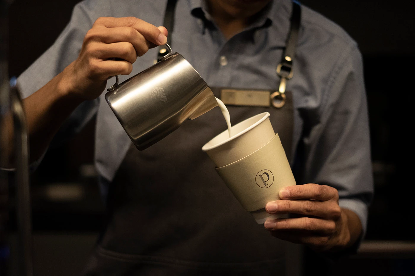 Page Common branding latte art pouring into takeaway cup