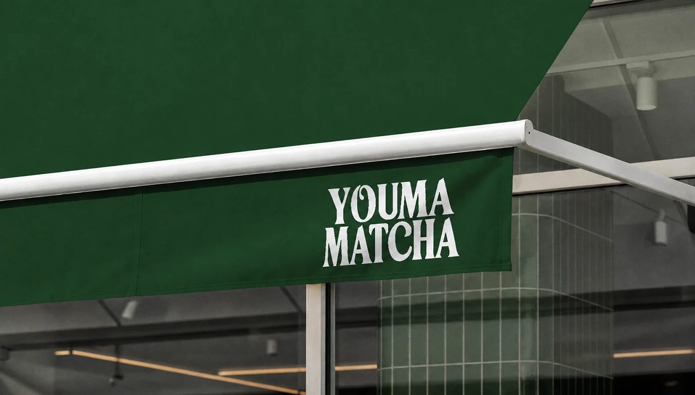 Youma Matcha branding storefront green awning with serif logo