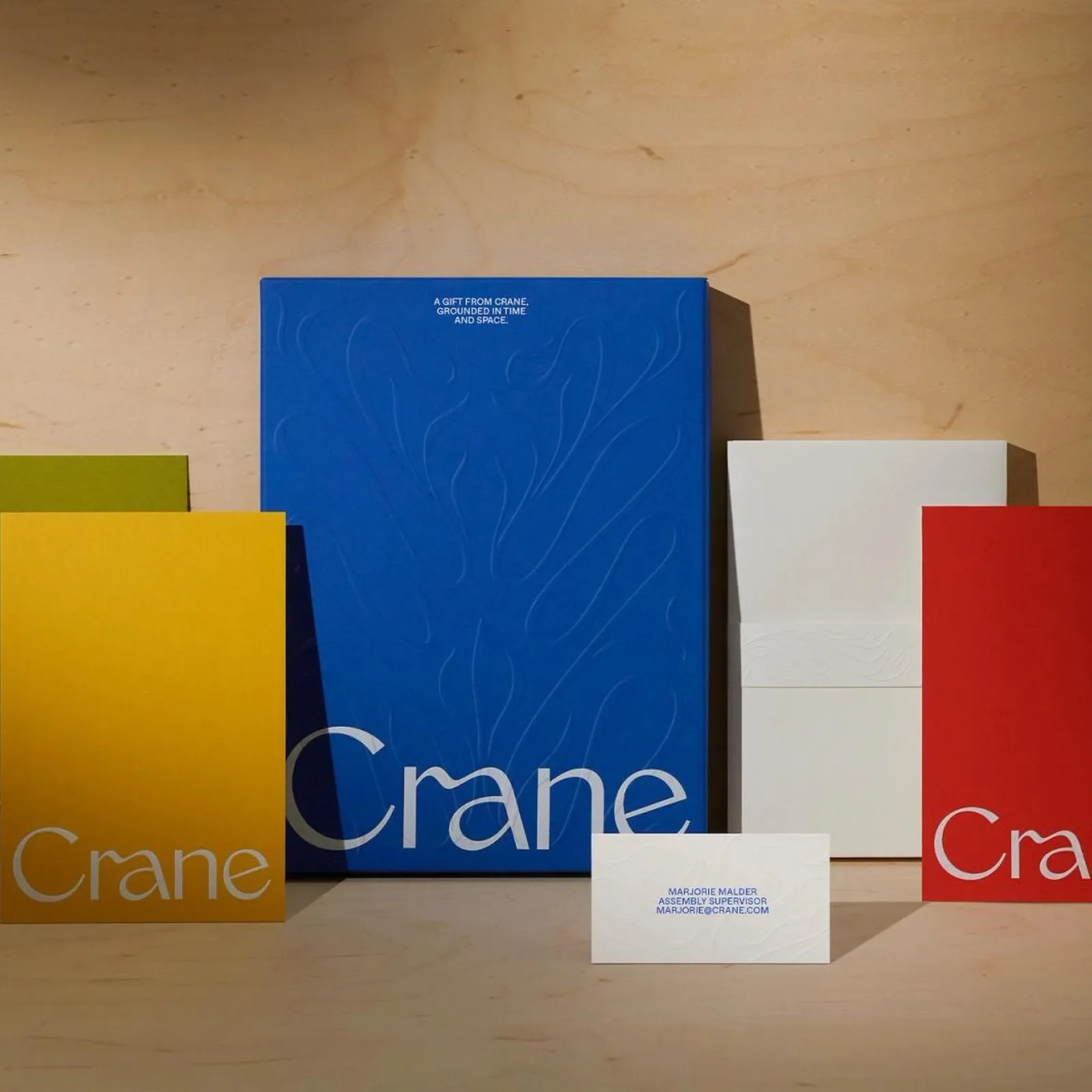 Crane branding and stationery system overview in cobalt blue, saffron yellow, olive green, and crimson red by COLLINS