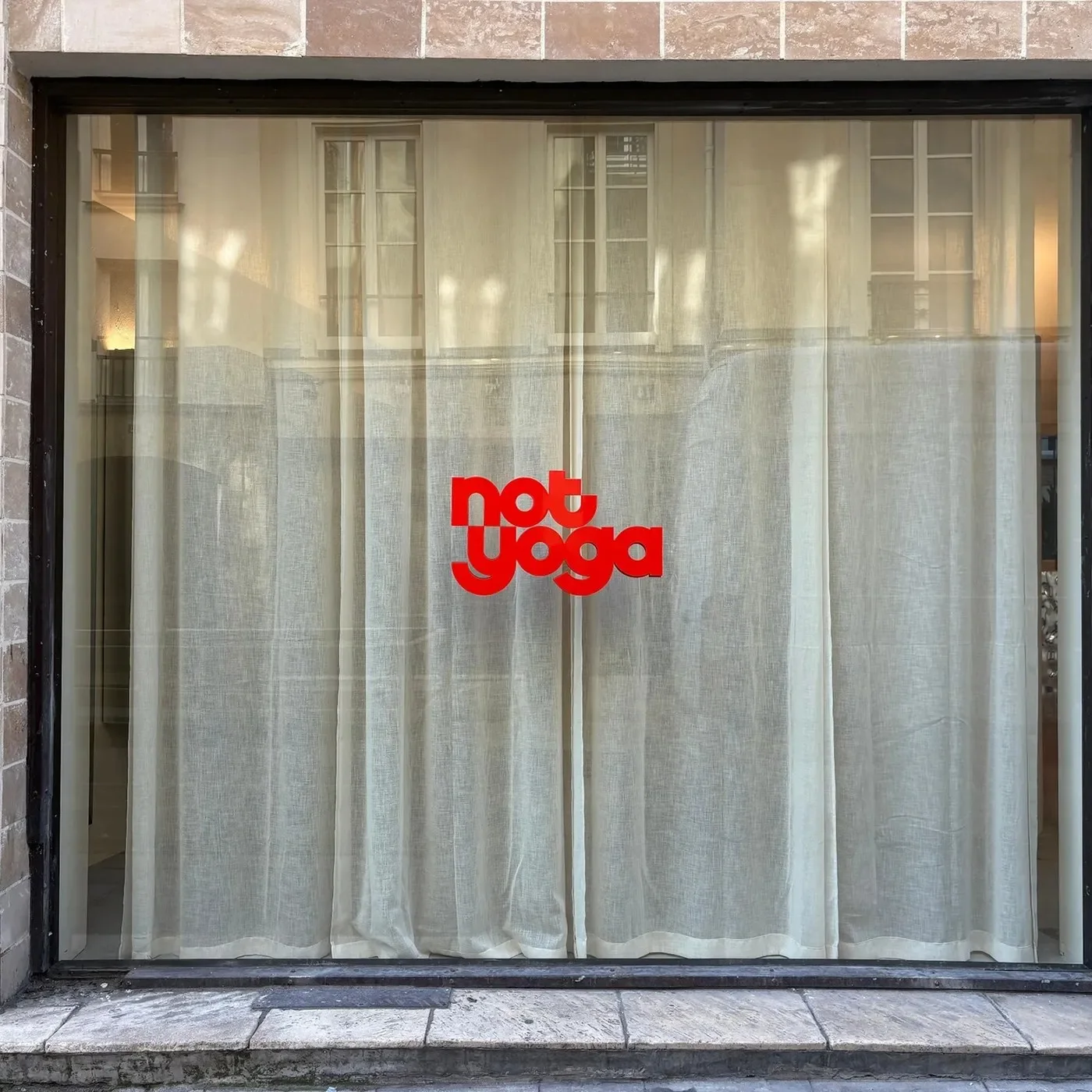visual identity brand overview with dimensional red logo and typography on Paris storefront window