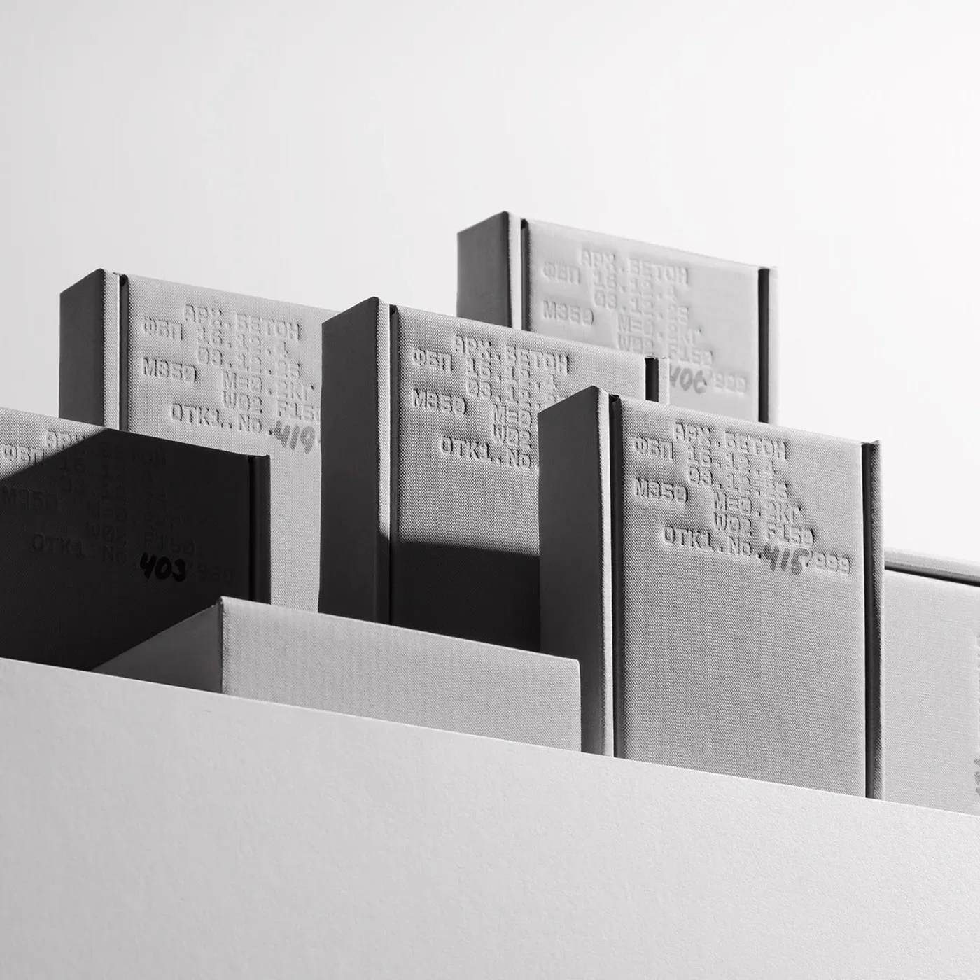 Rigid concrete grey book boxes showcasing industrial packaging design and stamped technical specifications