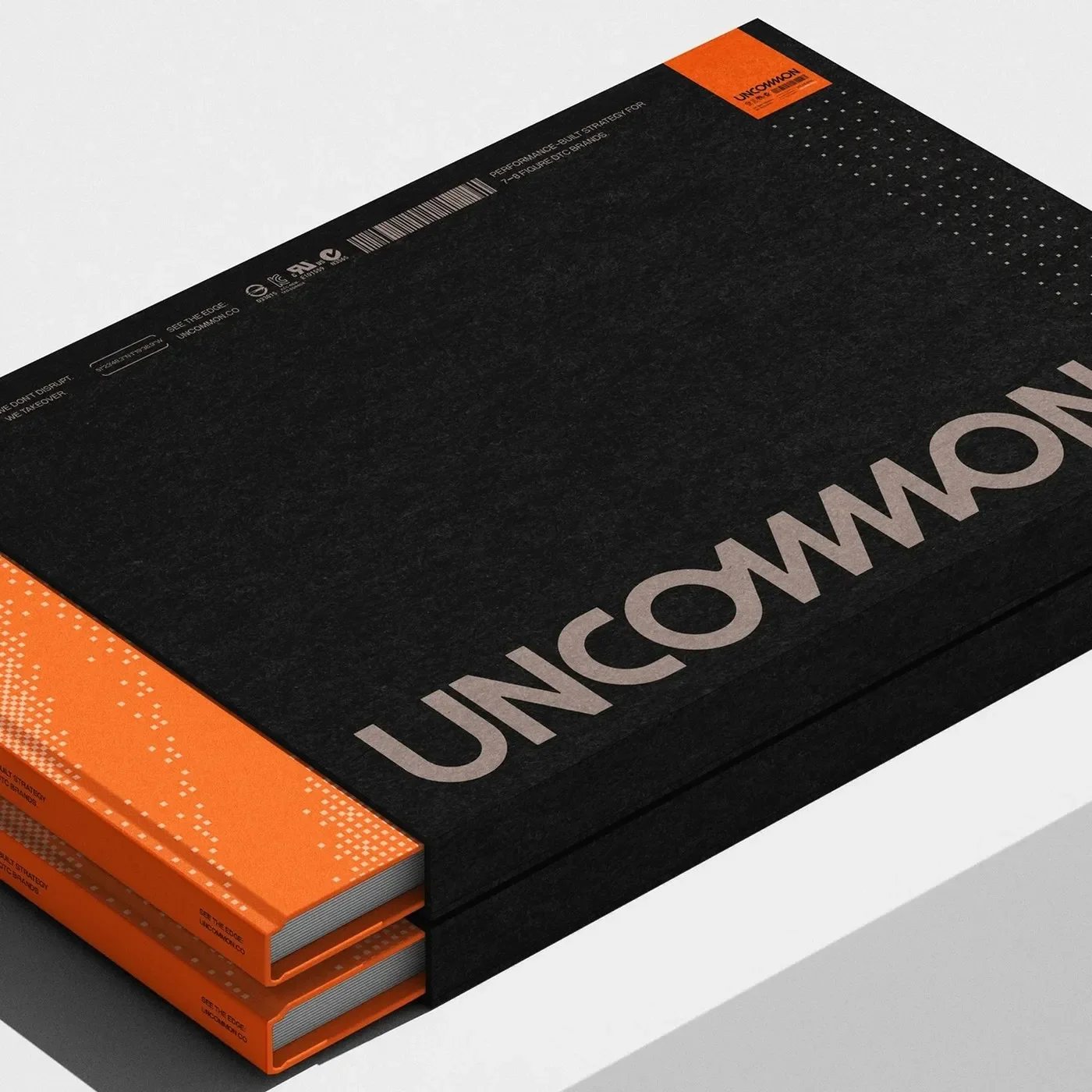 Uncommon brand identity textured black slipcase editorial book suite with safety orange telemetry