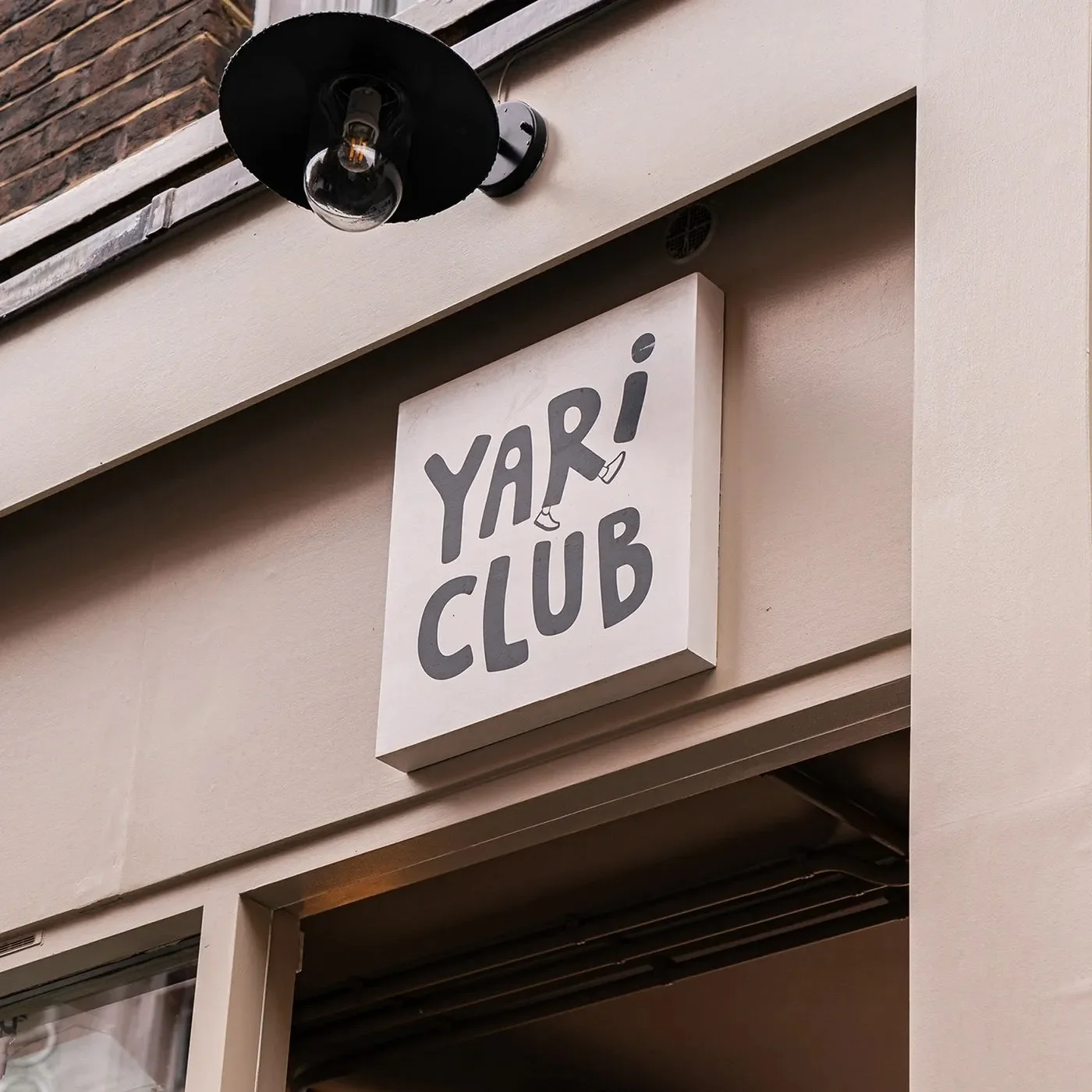 YARI CLUB restaurant brand identity vertical wordmark logo on charcoal packaging box.