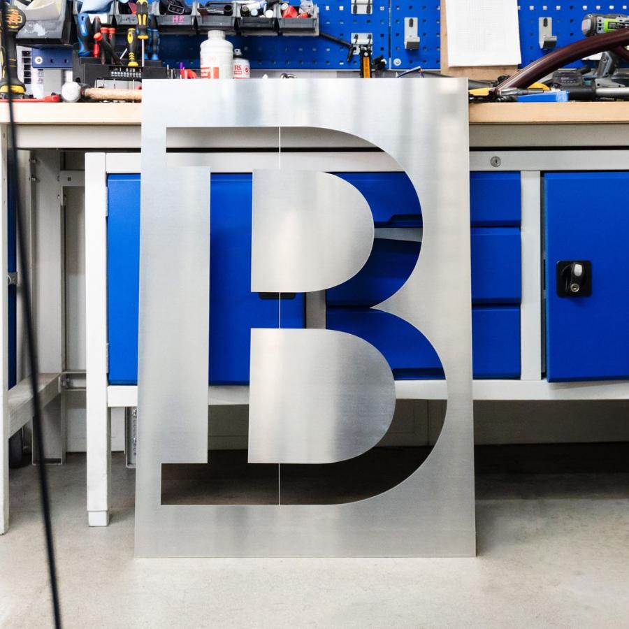 Brompton global branding brushed aluminum B stencil plate inside factory workshop