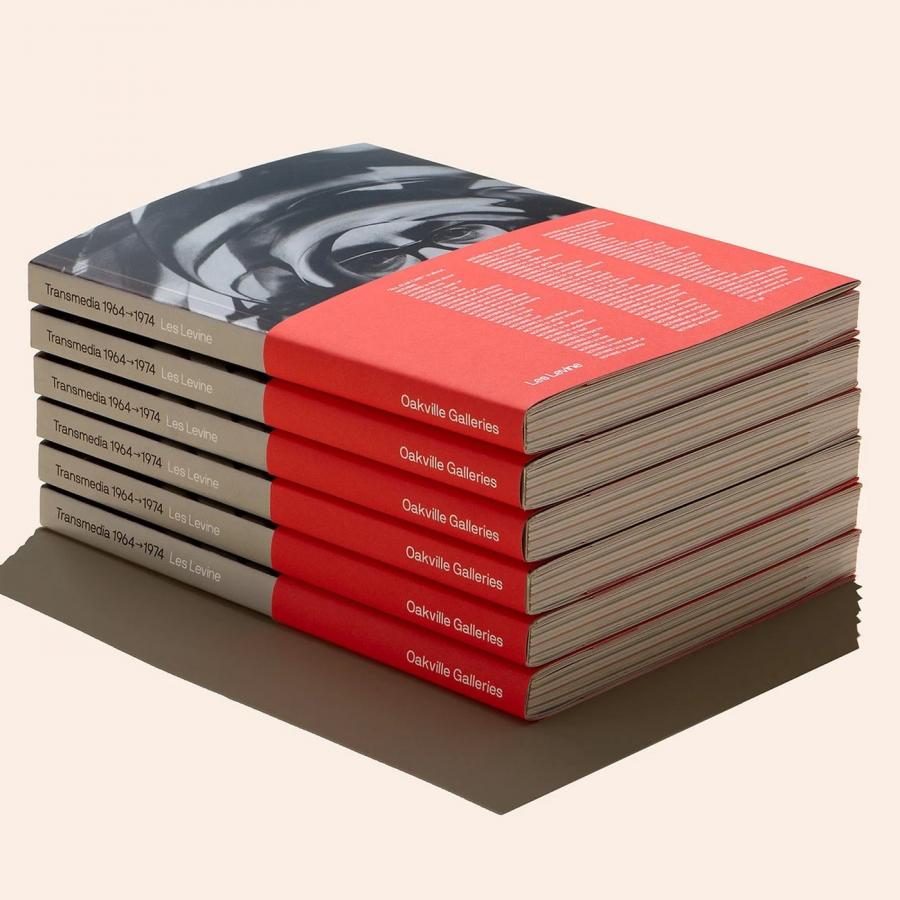 Tactile exhibition catalogue stack featuring red bellyband wraps and spine typography in editorial design by Underline Studio