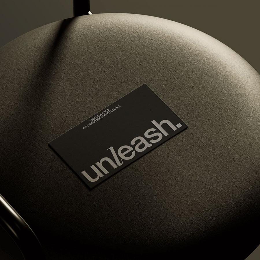 Unleash pet storytelling branding black foil-stamped business card on leather cushion by Stud Creative House